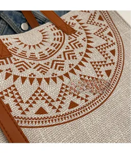 Detailed close-up of ethnic tote bag fabric showing brown geometric patterns and leather strap