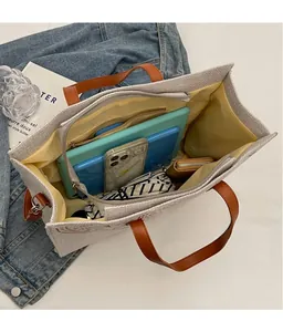 Detailed view of the spacious canvas tote bag interior with multiple everyday items