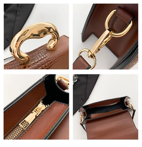 Detail of crocodile pattern leather handbag with gold fluid metal handle and zip pocket