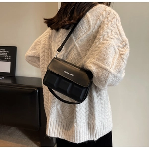 Detail of black crossbody bag with 3D cube texture and FASHION & BAGS logo detail