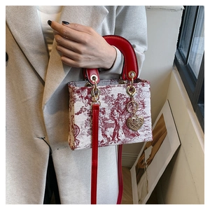 Detailed close-up of a white canvas tote with red Toile de Jouy pattern and heart charm