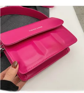 Detailed close-up of a magenta mini square bag with premium leather texture and 3D embossing
