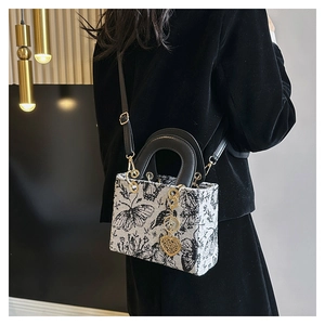 Detailed embroidery of butterfly and floral patterns with golden heart charm on tote bag