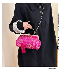 Close-up of rose red satin embroidery handbag with golden clouds and silk tassel detail