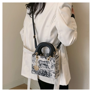 Detail of Toile de Jouy tiger print canvas bag with elegant heart charm and gold rings