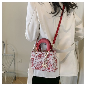Detailed back view of model wearing a red and white butterfly embroidery crossbody bag