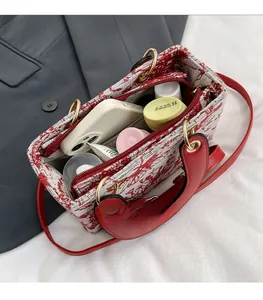 Top view of spacious interior with red floral embroidery pattern and leather handles