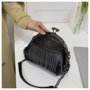 Detail der schwarzen Punk-Tasche mit Metallnieten und langen silbernen Perlenkettengrappen