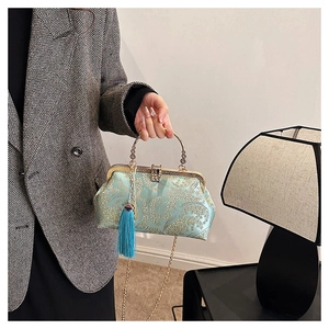 Detail of light cyan silk handbag with floral embroidery and elegant blue tassel