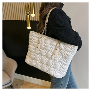Borsa tote trapuntata bianca con tracolla a catena dorata indossata da una modella