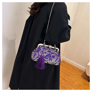 Close-up of vintage purple silk handbag with silver flower embroidery and long tassel