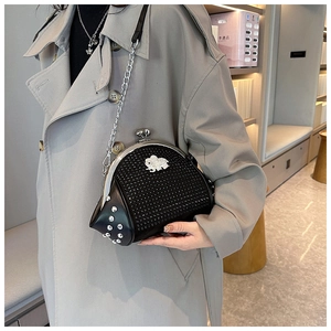 Detail view of black rhinestone shell bag with silver elephant emblem and metal chain
