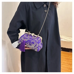 Detail of purple satin evening bag with gold floral embroidery and tassel
