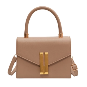 Minimalist camel crossbody handbag with gold buckle and textured leather on white background