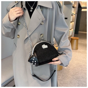 Detail of black rhinestone shell bag featuring a luxury diamond elephant clasp and chain