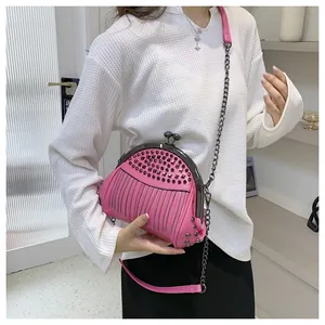 Detail der rosaroten Muscheltasche mit schwarzen Nieten und Kettenriemen am Modell