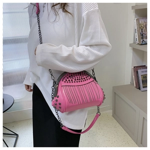 Detailansicht der rosa Umhängetasche mit Nieten und Quastenkette an einem Modell