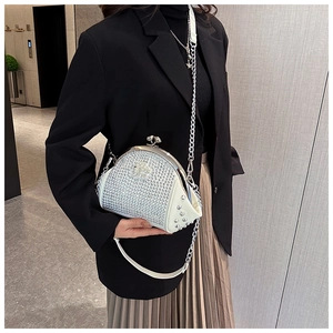 Detail of white evening bag featuring silver rhinestones and a metal chain strap