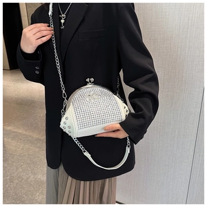 Detail of white shell-shaped evening bag with silver rhinestones and metal chain strap