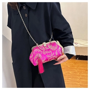 Gros plan détaillé du sac de broderie chinoise fuchsia avec des motifs floraux dorés