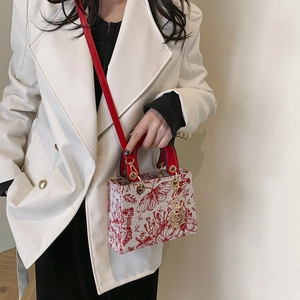 Chic tote bag with red butterfly embroidery and red leather handles on white base