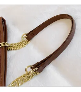 Dettaglio della borsa trapuntata marrone con manico in pelle e tracolla a catena d'oro