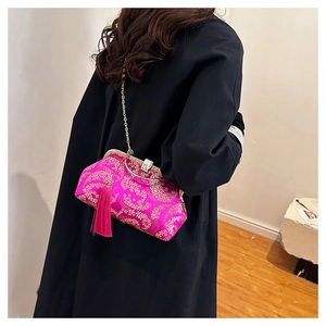 Detail of rose red Chinese silk brocade evening bag with gold floral pattern and long tassel