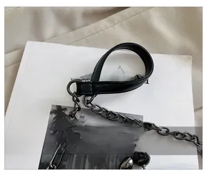 Detail des schwarzen Ledergriffs mit dunkler Metallkette und Ringschnalle der Tasche