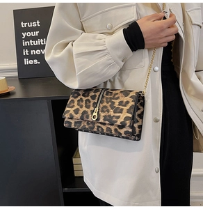 Detail shot of leopard print flap bag with gold chain strap and vertical zipper accent