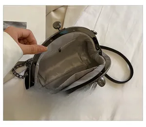 Innendetails der schwarzen Clip-Tasche mit Fischgrätfutter und Metallkettenriemen