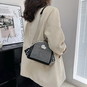 Fashionable black leather shell bag with rhinestones and elephant charm on a chain strap