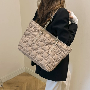Borsa tote beige trapuntata con cuciture a rombi e tracolla in catena per uso quotidiano