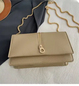Detailed view of khaki crossgrain leather bag with golden chain and vertical zipper