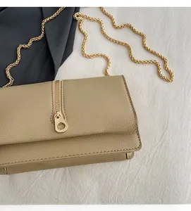 Detail of khaki crossbody bag with cross-grain leather texture and golden metal zipper