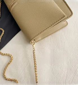 Detail of khaki lychee grain leather texture and detachable gold metal chain hook