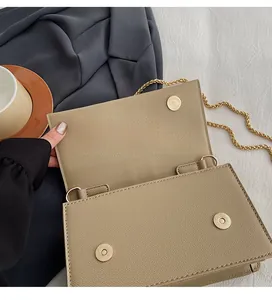 Detail of premium golden magnetic clasps on beige cross-grain leather chain bag