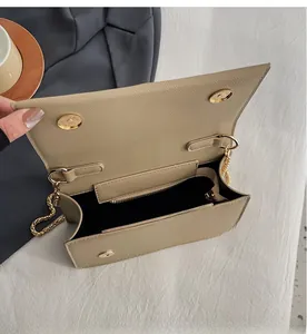 Interior view of beige litchi leather bag showing compartments and golden chain