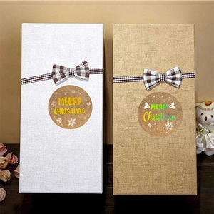 Kraft paper Merry Christmas stickers on gift boxes with checkered bows and rustic decor