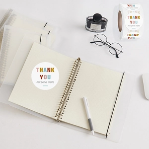 Colorful Thank You For Your Order stickers roll on desk with office stationery tools