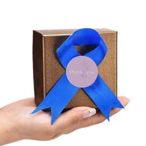 Nordic thank you floral stickers with blue ribbon on small golden gift box for packing