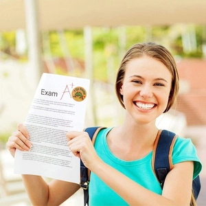 Smiling teacher holding A+ exam paper with green lizard reward sticker saying You Shine