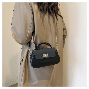 Close-up of black matte leather handbag with silver chain strap and metal swivel lock