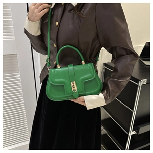 Détail d'un sac porté épaule en PU vert avec rabat géométrique et fermoir métallique doré