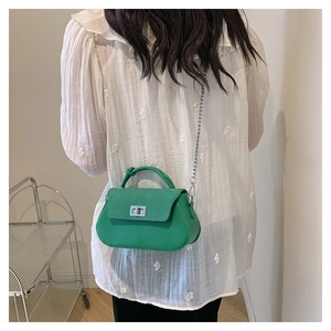 Back view of model wearing a green small chain crossbody bag with silver lock