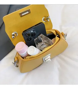 Interior view of yellow chain bag showing storage capacity for phone and cosmetics