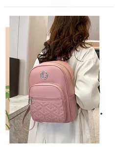 Pink backpack detail showing Y-shaped geometric quilting and metallic round logo finish