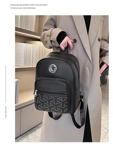 Detail of black leather backpack with geometric embroidery and silver metal logo