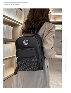 Detail of black leather backpack featuring embroidered Y-pattern and metal G-logo