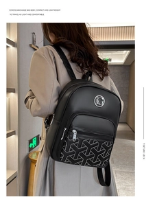Detail view of black leather backpack featuring white geometric stitching and silver logo