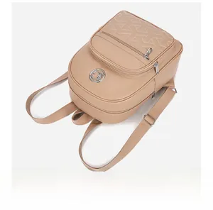 Detail view of beige PU leather backpack featuring geometric quilting and silver metal logo